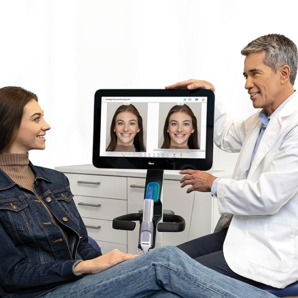 Doctor de Invisalign® enseñando a su paciente el posible antes y el después de su sonrisa con la tecnología ClinCheck